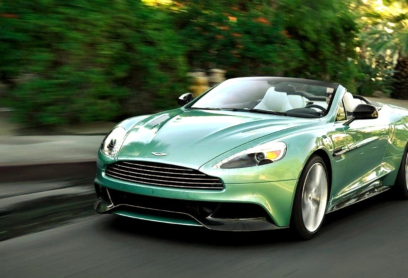 Green Aston Martin Convertible Speeding Down the Road